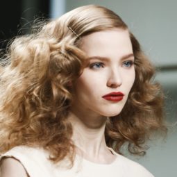 runway shot of a brunette model with 1920s screen siren curly frizzy hair