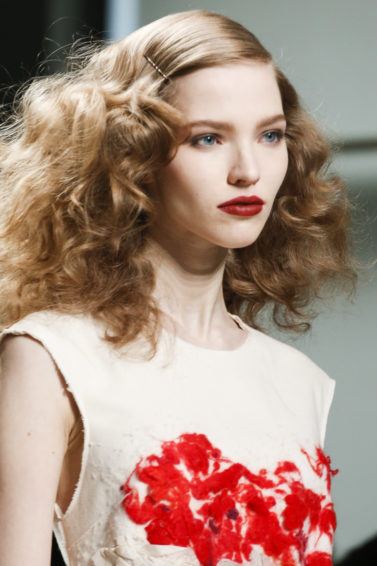 runway shot of a brunette model with 1920s screen siren curly frizzy hair