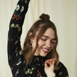 Woman with short wavy brown hair half up bun