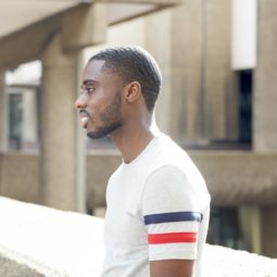 360 waves: Man with short afro hair in 360 waves with facial hair wearing a grey t-shirt, standing outside