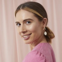 Brunette model with blonde streaks with her hair in a sleek low looped ponytail