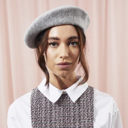 Woman with beret and low updo with face-framing tendrils