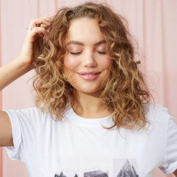 Woman touching her curly blonde hair