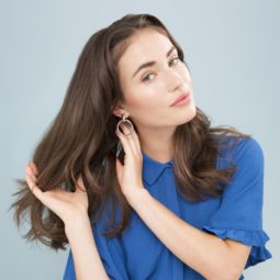 model touching hair wavy hair wearing blue and floral print trousers