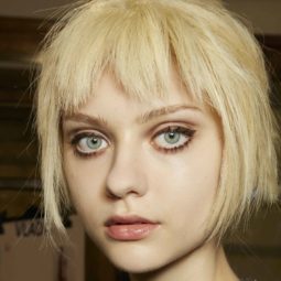 close up shot of a model with flaxen blonde hair cut into a choppy bob and fringe