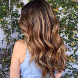 rear view of a woman with wavy long hair on the floral background