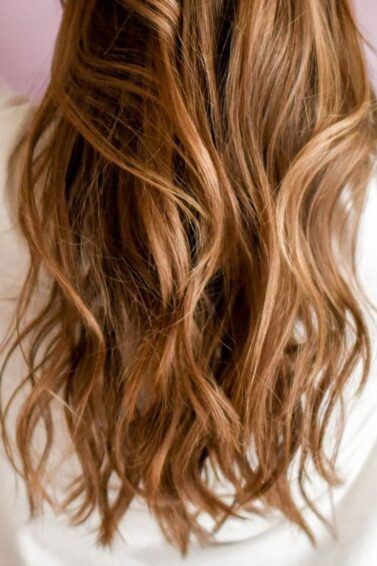 Woman with caramel balayage hair with pretty waves.