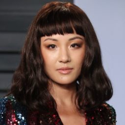 close up shot of constance wu on the red carpet with blunt cut bangs, wearing glittery dress on the oscars red carpet