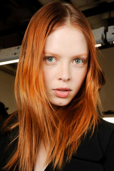 model backstage at fashion show with warm copper red hair