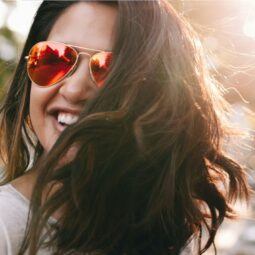 Women in street wearing sunglasses and looking happy