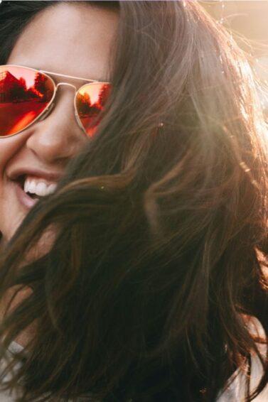 Women in street wearing sunglasses and looking happy