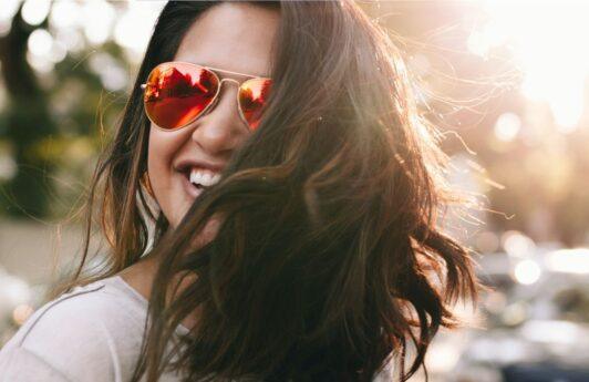 Women in street wearing sunglasses and looking happy