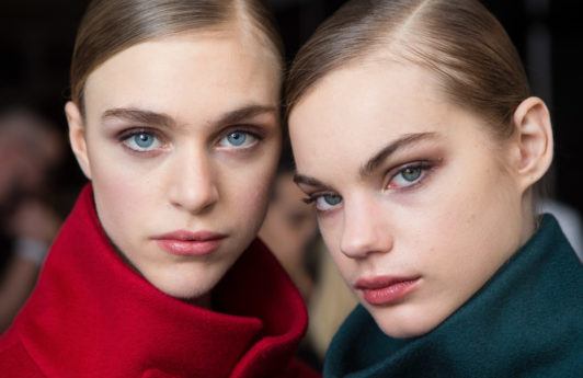 models with slick precise part hairstyle backstage carolina herrera