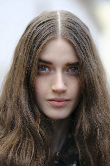 cream for dry hair guide: close up shot of woman with dry, wavy hair, posing for a streetstyle shot