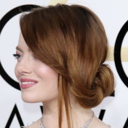 side view of emma stone with a side sweeping undone bun updo at golden globes