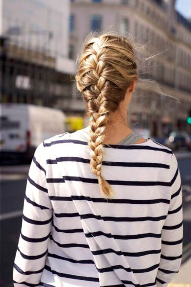 back view of a woman's hair with a golden-blonde-french-braid