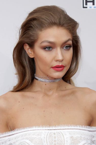 gigi hadid wearing strapless dress and red lipstick with relaxed quiff rockabilly hairstyle