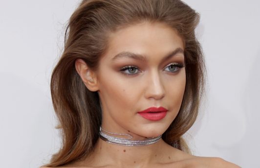 gigi hadid wearing strapless dress and red lipstick with relaxed quiff rockabilly hairstyle