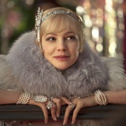 close up shot of carey mulligan as daisy buchanan, wearing a furry scarf, a flapper dress and a silver hairband hair accessory with pixie haircut, on the set of The Great Gatsby