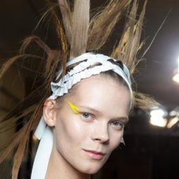 model backstage at the Haider Ackermann SS17 show with extreme spiky hair with a bandage wrapped around her head with a wing of colourful eyeliner