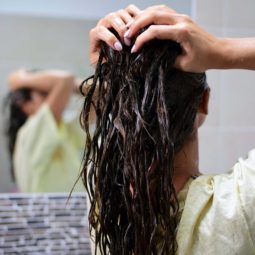 back view of model running hands through wet hair