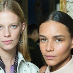 Two models backstage at the Bottega Veneta show with smooth, straight hair staring into the camera