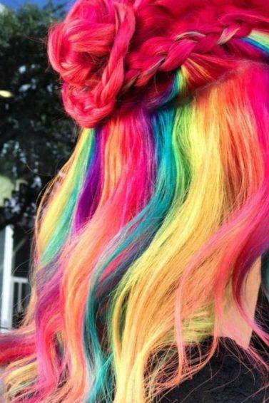 woman with froot loops inspired cereal hair styled into a half up braided bun at salon