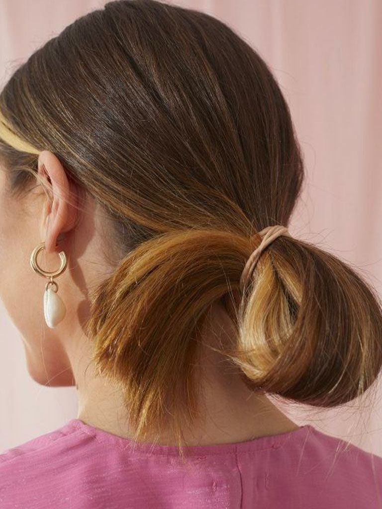 Woman with long hair styled into a looped ponytail