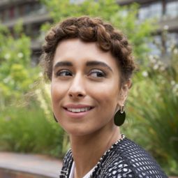 woman with natural curly hair in a halo braid outside