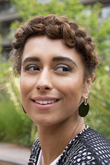 woman with natural curly hair in a halo braid outside