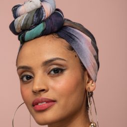 How to wear a headscarf: Model with pattern headscarf wrapped in a twisted top knot bun.