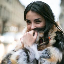 Hot oil treatment: Woman with long dark brown tousled hair, wearing big fluffy jacket outside