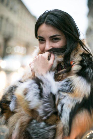 Hot oil treatment: Woman with long dark brown tousled hair, wearing big fluffy jacket outside