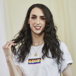 woman with long curly hair smiling at the camera