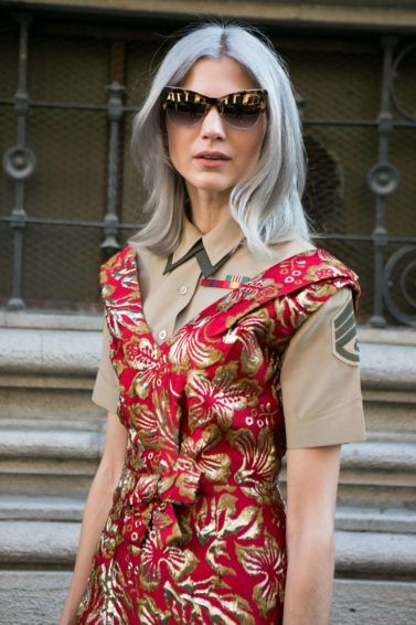 street style blogger at milan fashion week wearing a red floral dress with grey medium length hair