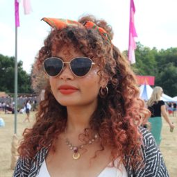 Festival hair accessories: Woman with naturally curly hair styled in a half-up, half-down bun wrapped in a headscarf