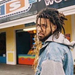 J Cole with half-up dreadlocks hairstyle and beard