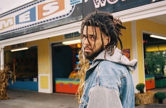 J Cole with half-up dreadlocks hairstyle and beard