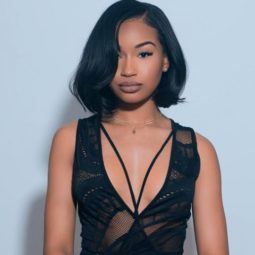 close up shot of woman with short sleek weave hairstyle with side swept fringe, wearing all black and posing