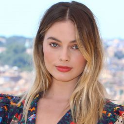 Margot Robbie with brunette to blonde hair with grown-out roots