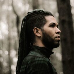 Black man with long braids with taper undercut