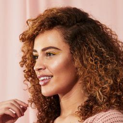 Woman with brunette natural hair with caramel highlights