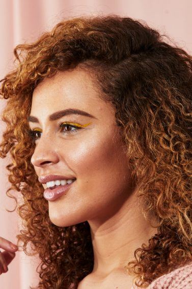 Woman with brunette natural hair with caramel highlights