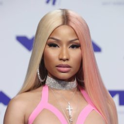 close up shot of nicki minaj with two tone hair that's blonde and pink hair, wearing silver and latex dress