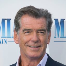 Hairstyles for men over 50: Pierce Brosnan with grey short hair swept back wearing a relaxed blue suit at Mamma Mia premiere.