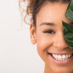 Woman with brunette curly hair holding a leaf