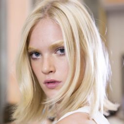 model with a platinum blonde bob with flicked ends and bleached eyebrows