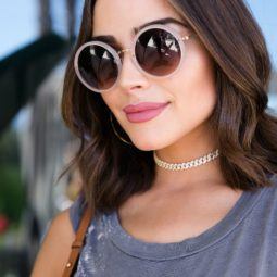 medium bob hairstyles: olivia culpo with short wavy bob hairstyle wearing sunglasses and smiling