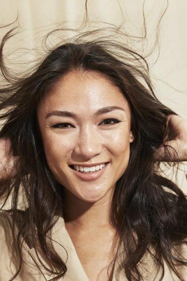 Woman touching her long healthy dark hair