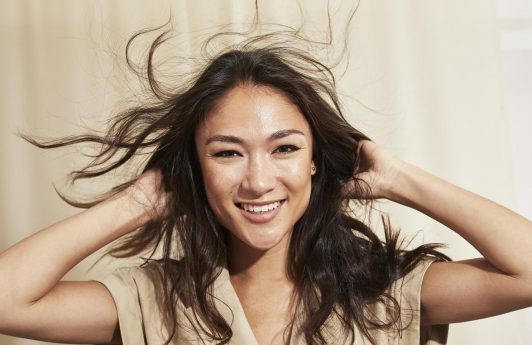 Woman touching her long healthy dark hair